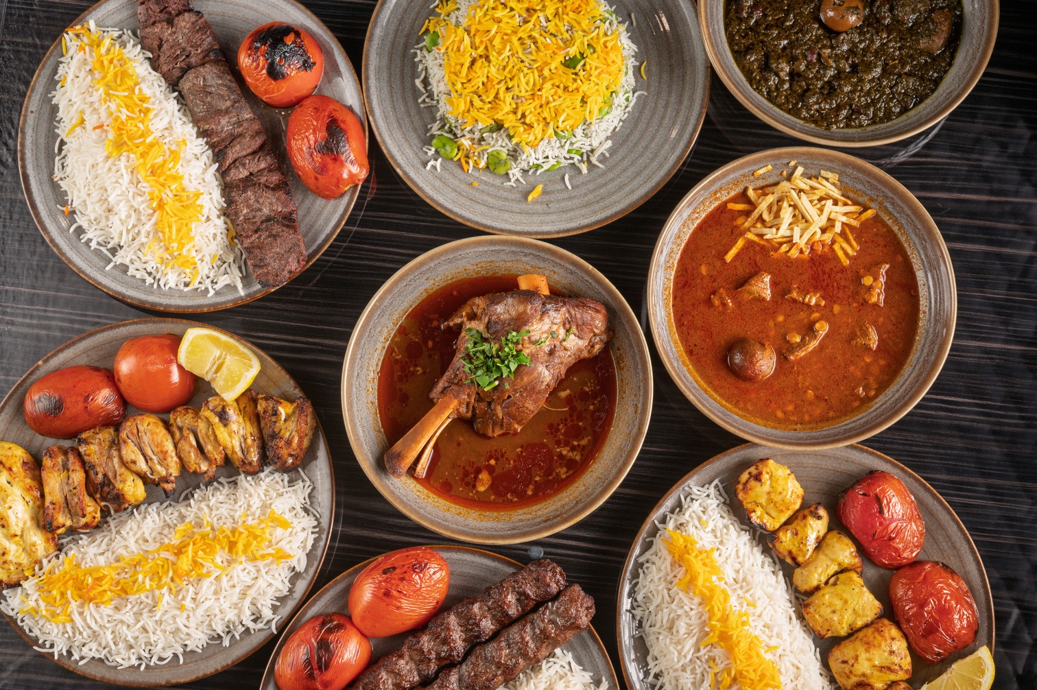 An elegant Persian dining table featuring rice, stews, and kababs at a Houston restaurant