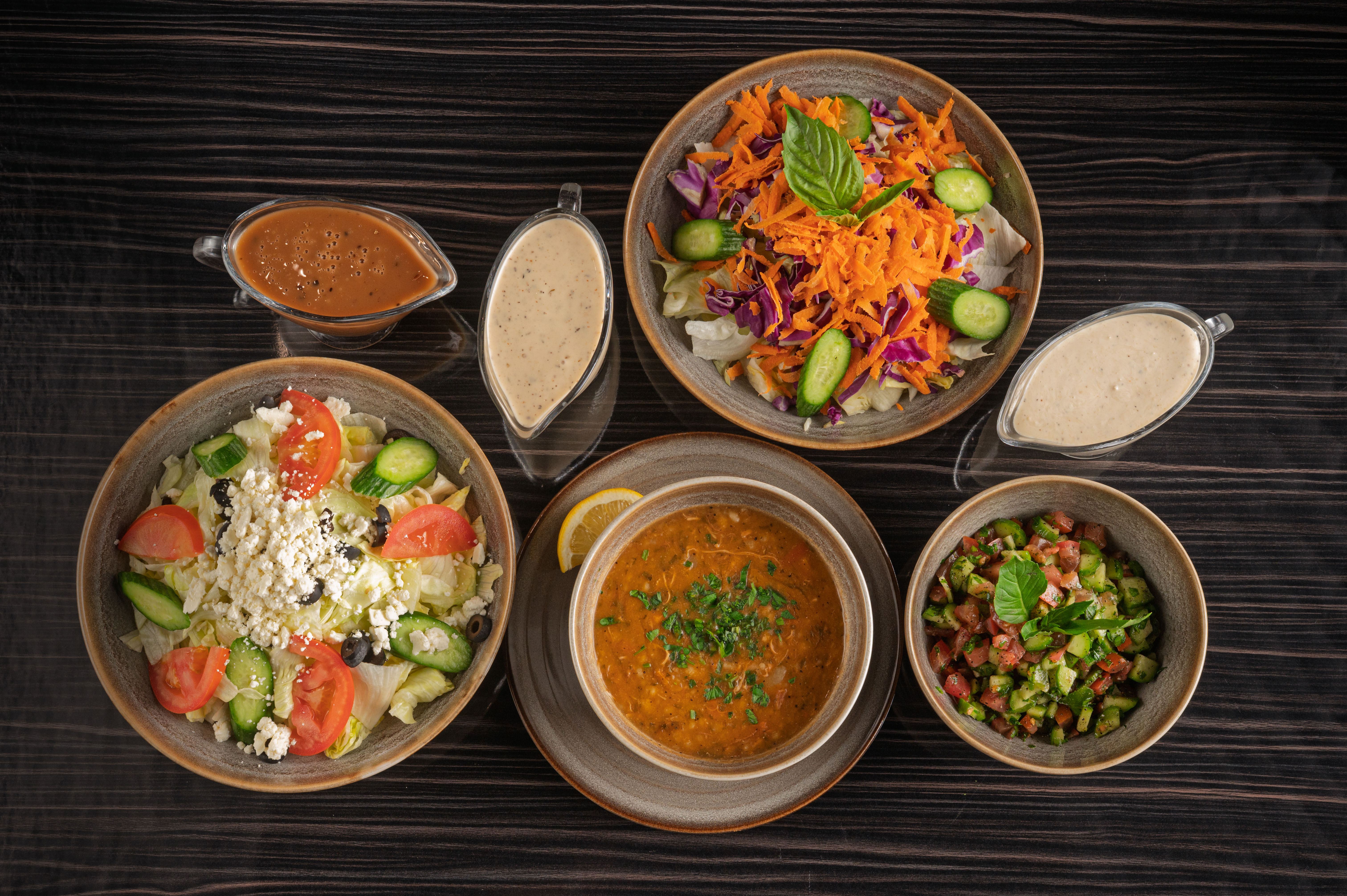 Persian appetizers for catering including Hummus and Shirazi Salad on a buffet table